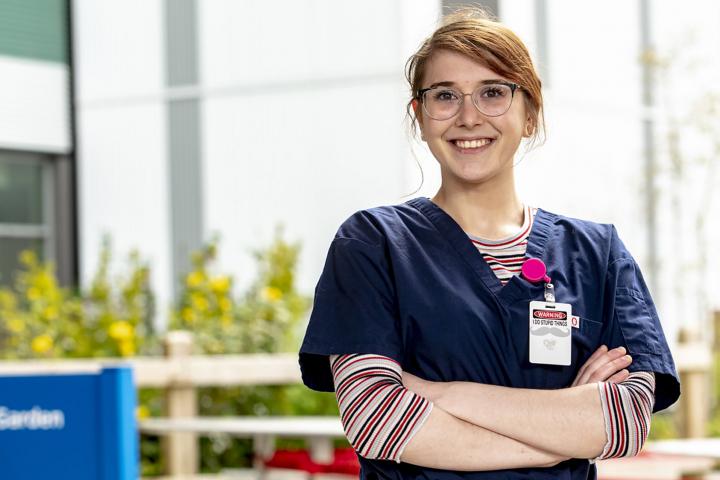 Healthcare worker arms crossed smiling