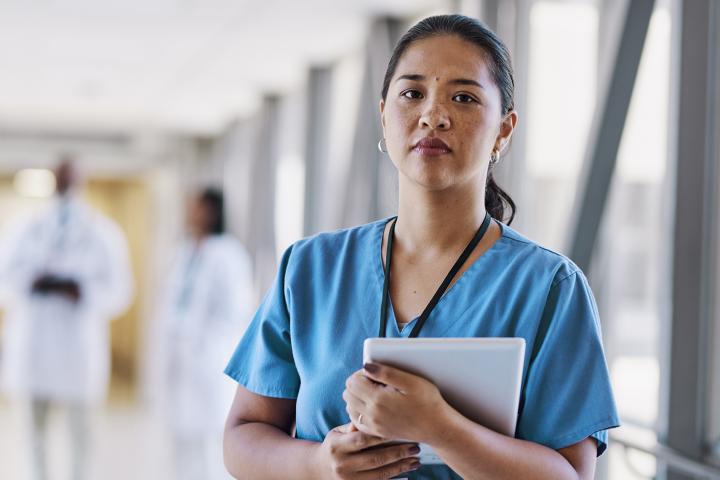 health care worker holding tablet in hallway