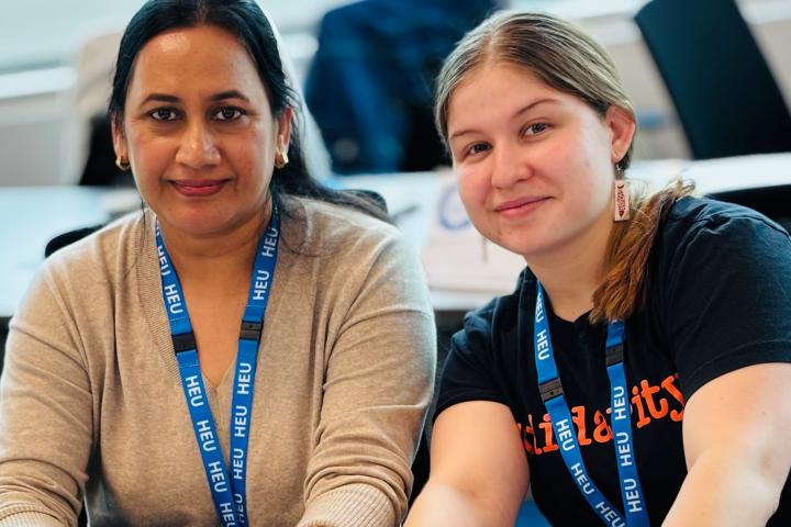 Two smiling HEU members at a meeting