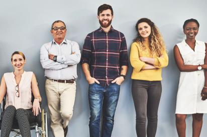 Diverse group standing against wall