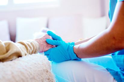 health care worker holding hands with senior